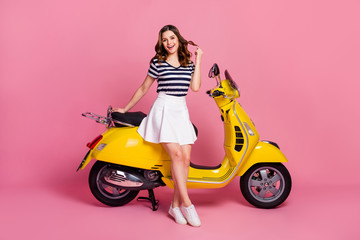 Fototapeta na wymiar Portrait of her she nice attractive lovely cheerful cheery girl sitting on moped playing with curl rent rental service buy credit loan sale isolated on pink pastel color background