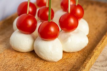 Canape on caprese skewers with cherry and mozzarella. Nice decorated catering banquet menu