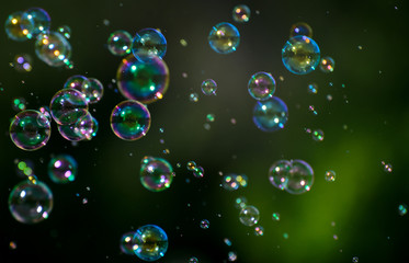 soap bubbles fly on a blurry green background. Concept - the Phantom of Hopes
