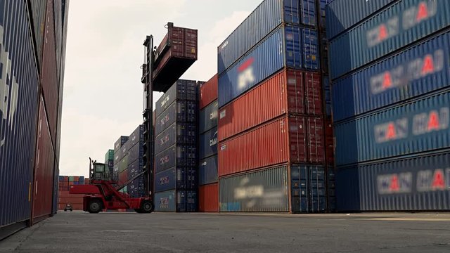 Forklift trucks are stacking containers in the warehouse.Freight business, transportation
