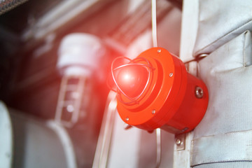 Fire alarm with red warning light of an emergency beacon at an industrial facility. - obrazy, fototapety, plakaty