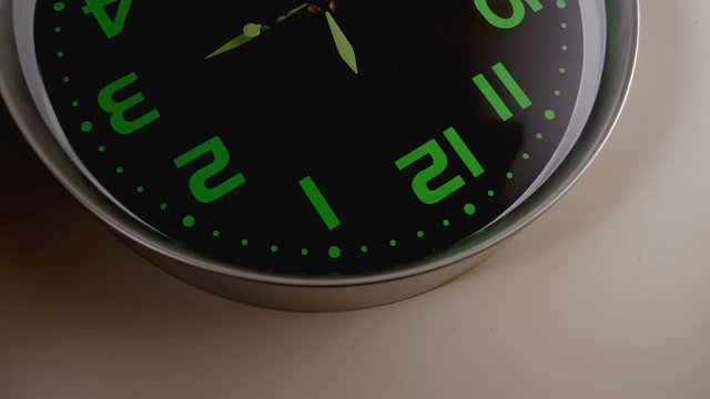  reverse image of a wall clock with with the clock hands spinning