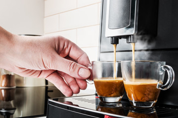 woman's hand takes a glass Cup of coffee Prepared on the coffee machine