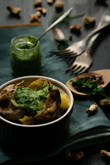Baked potato with green pesto sauce with cheese