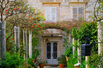 Ancient buildings with historic facades in decay and beautiful, magical and enchanted gardens in...