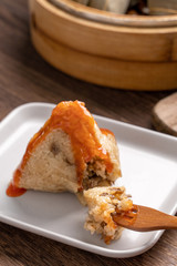 Dragon Boat Festival food - Rice dumpling zongzi, young Asian woman eating Chinese traditional food on wooden table at home celebration, close up