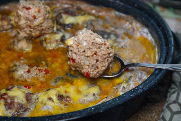 Homemade baked  meatballs with vegetables and rice cooked in tomatoe and sour cream sauce.