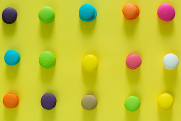 Sweet colorful macaroons on yellow background