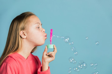 Cute girl with Down Syndrome blowing bubbles