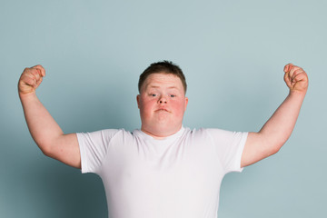 Proud boy with down syndrome flexing his arms