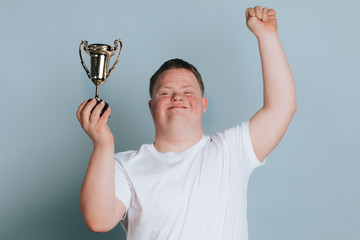 Cute boy with down syndrome holding a trophy © rawpixel.com
