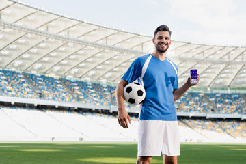 professional soccer player in blue and white uniform with ball showing smartphone with heartbeat rate on screen at stadium © LIGHTFIELD STUDIOS