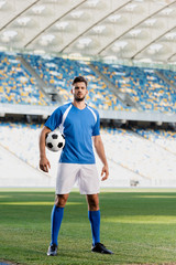 professional soccer player in blue and white uniform with ball on football pitch at stadium © LIGHTFIELD STUDIOS