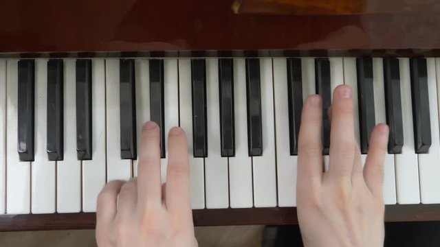 view from above. closeup. female hands masterfully play the piano
