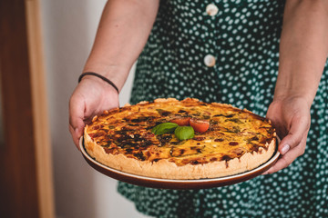 woman hands holding a quiche