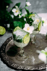Cold cocktail with mint, lime and ice in a glass