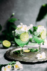 Cold cocktail with mint, lime and ice in a glass