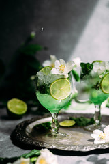 Cold cocktail with mint, lime and ice in a glass