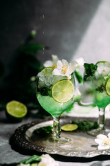Cold cocktail with mint, lime and ice in a glass