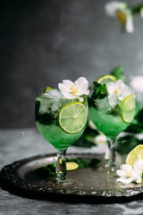 Cold cocktail with mint, lime and ice in a glass