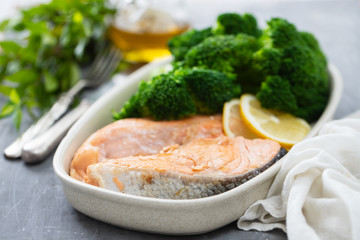 salmon with broccoli in dish on ceramic background