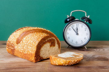 alarm clock and marble bread on a wooden table