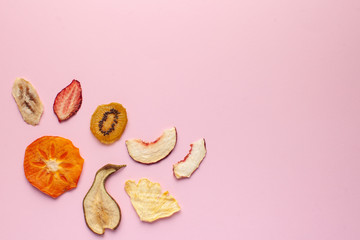  Dried fruit chips on pink background. The concept of healthy snack without sugar, dessert for vegetarians. Copy space.