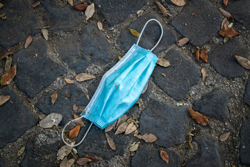 Protective mask abandoned on the road, on the ground. Symbol of the end of the restrictions for the...