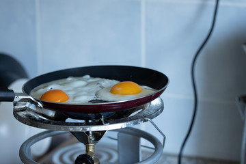 2 scrambled eggs on the pan. On the gas cylinder. Close up.