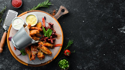 Snacks to beer on the board. Chicken wings, nuggets, sausages. Top view. Free space for your text.