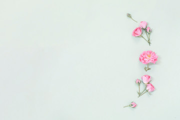 Flower composition. Pattern made with small rose flowers on a soft background. Top view with copy space for text