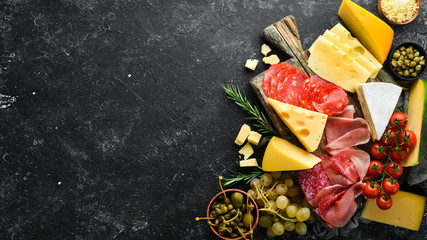 Appetizers table with italian antipasti snacks and wine in glasses. Cheese, wine, salami and...
