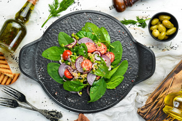 Healthy vegan salad of spinach, quinoa, tomatoes and vegetables. Top view. Rustic style.