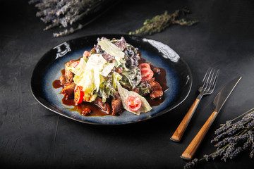 Warm beef salad with white sauce and greens