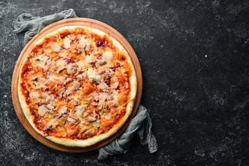 Traditional pizza with tuna and vegetables. Top view. free space for your text. Rustic style.