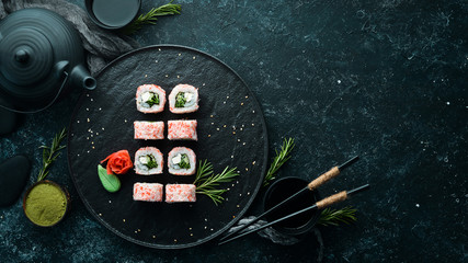 Japanese sushi with crab sticks, cheese, onion and cucumber. Asian Diet Food. Top view. © Yaruniv-Studio