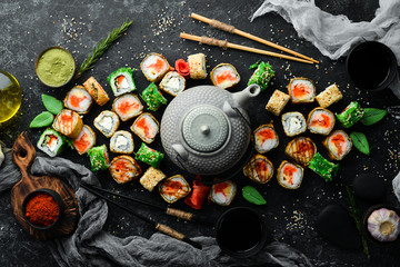 Set sushi rolls and tea ceremony with a teapot. Top view. Free space for your text.