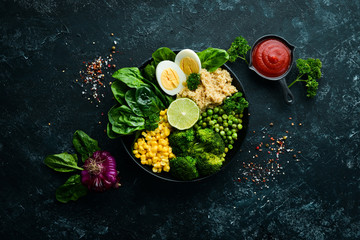 Green vegetable bowl Buddha. quinoa, green peas, corn, spinach, broccoli, egg. Healthy food. Top view. Free space for your text.