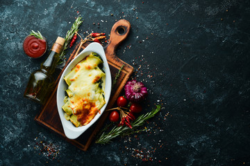 Cannelloni paste baked with spinach, cream sauce, cheese. Italian cuisine. Top view. Free copy space.