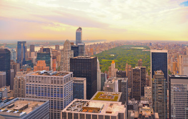 Fototapeta premium Widok z lotu ptaka na dachy Manhattanu, park centralny i horyzont z niebieskim pochmurnym niebem na Manhattanie w Nowym Jorku