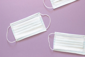 three white medical mask to protect the face from the virus on a blue purple background with space for text