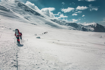 Scenic landscape of snowy mountains. Pamir Mountain System. Climbers making the ascent.