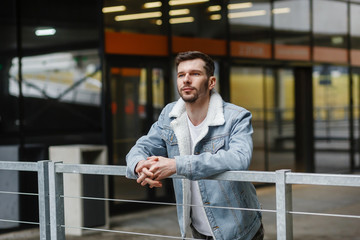 portrait of a guy in stylish clothes on a background of city streets