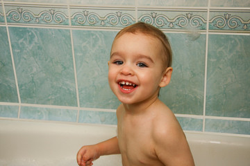 Baby bathing in the bathroom. Close up portrait of a happy bathing baby
