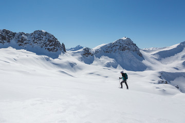 Fototapeta na wymiar women with snowshoes walking in snowy winter landscape in Schanfigg