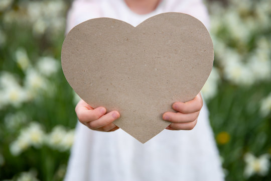 The Girl Gives A Paper Heart For Mother's Day, Father's Day, Birthday, Apology Among Flowers