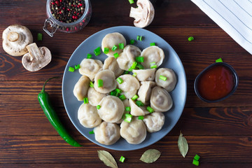 dumplings on a plate, decorated with green onions, view from above