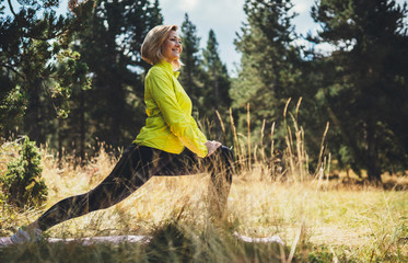 Fun girl exercising outdoors in sun summer day in park, activity with stretch legs. Smile fitness...