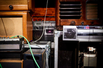 Tower built from old disused analog radios, amplifiers, cassette recorders and a phonograph. Old...