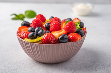 Fresh fruit salad with different ingredients with mint and sour cream. Healthy diet. Copy space for text. Close up